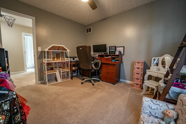 home office with ceiling fan, carpet floors, and a textured ceiling