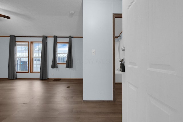 spare room featuring ceiling fan and dark wood-type flooring