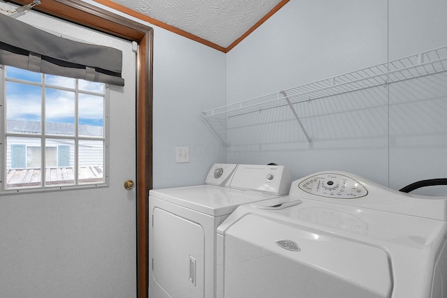 laundry room featuring independent washer and dryer, a textured ceiling, and crown molding