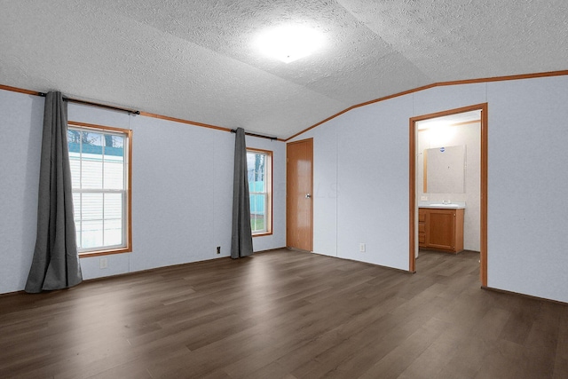 spare room with a textured ceiling, dark hardwood / wood-style flooring, lofted ceiling, and ornamental molding