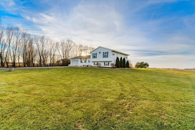 view of yard with a rural view and a garage