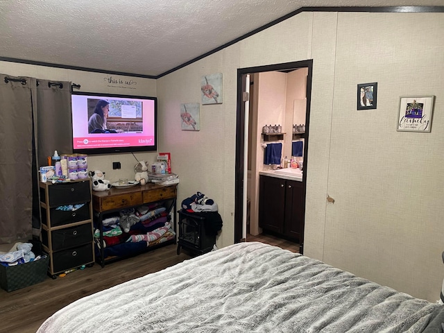 bedroom with lofted ceiling, dark wood-type flooring, ensuite bathroom, ornamental molding, and a textured ceiling