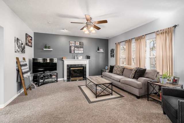 carpeted living room featuring a tile fireplace, ceiling fan, and a textured ceiling