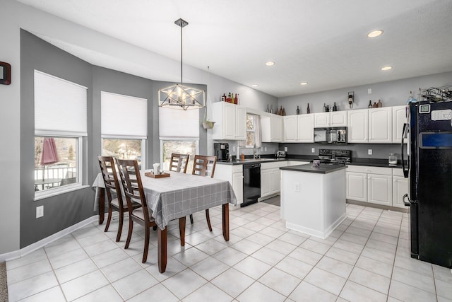 kitchen featuring white cabinets, pendant lighting, light tile patterned floors, and black appliances