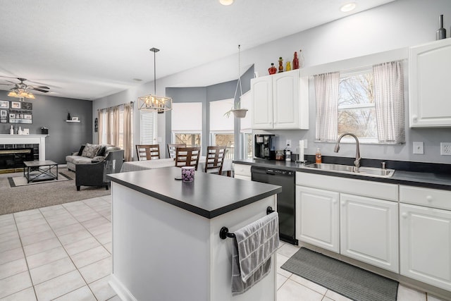 kitchen with dishwasher, sink, pendant lighting, a fireplace, and white cabinets