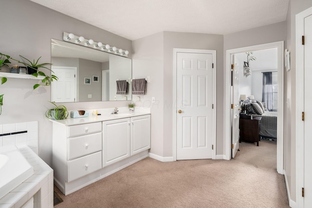 bathroom featuring vanity, a bath, and a textured ceiling