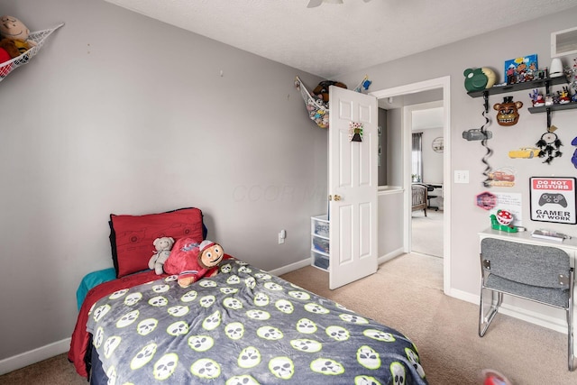 carpeted bedroom featuring ceiling fan and a textured ceiling