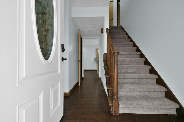 stairs with hardwood / wood-style flooring and a textured ceiling