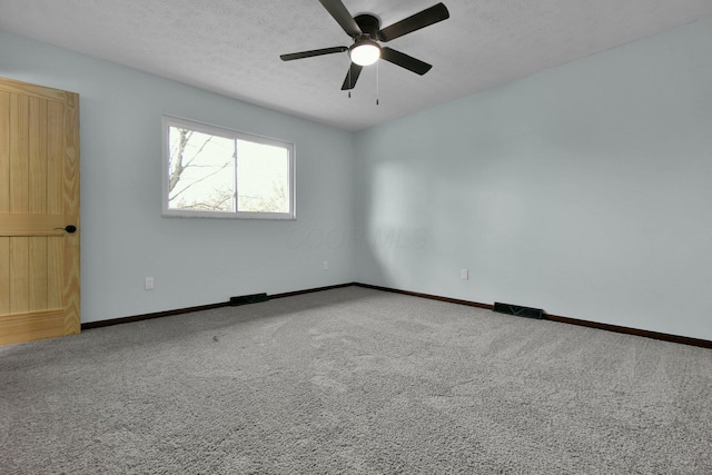 empty room with ceiling fan, carpet floors, and a textured ceiling