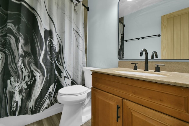 bathroom with hardwood / wood-style floors, vanity, a shower with shower curtain, and toilet