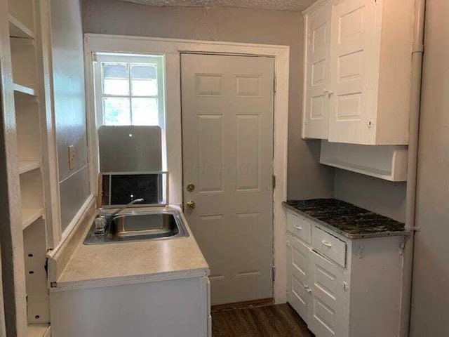 kitchen with white cabinetry, sink, and dark wood-type flooring