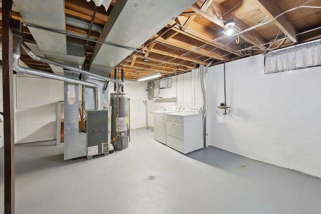 basement featuring washer and clothes dryer, heating unit, and water heater