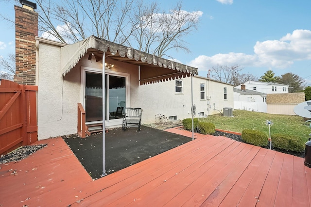 deck featuring a lawn and central AC