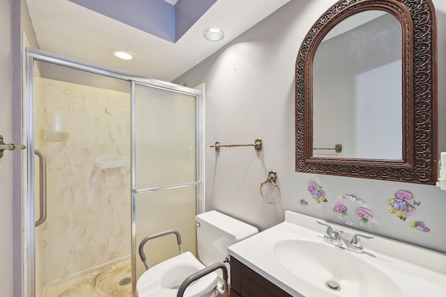 bathroom featuring a shower with door, vanity, and toilet