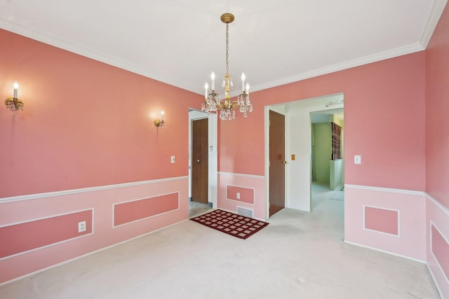 carpeted empty room with a chandelier and ornamental molding