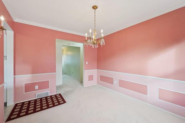 carpeted spare room with ornamental molding and a notable chandelier