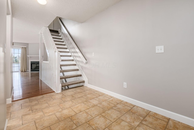 stairs with hardwood / wood-style floors and a textured ceiling