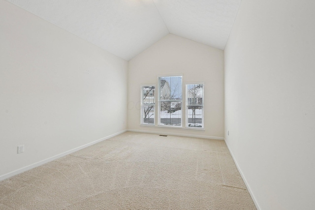 unfurnished room with lofted ceiling and light carpet