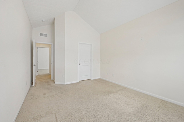 unfurnished bedroom featuring lofted ceiling and light carpet