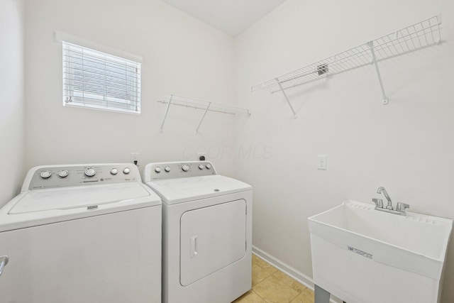 clothes washing area with sink, washing machine and dryer, and light tile patterned floors