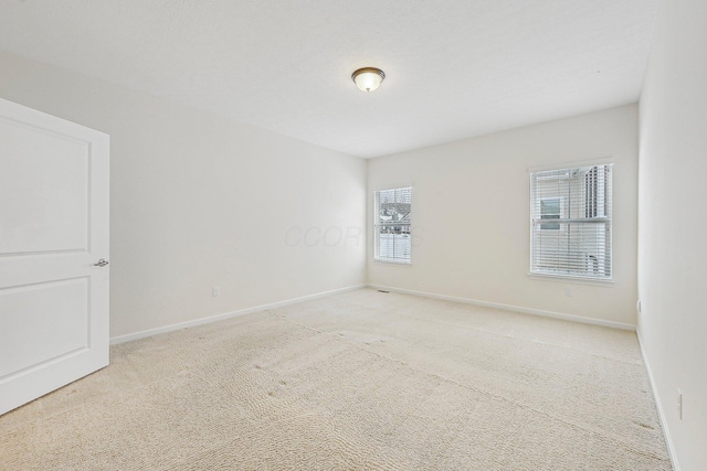 carpeted spare room featuring plenty of natural light