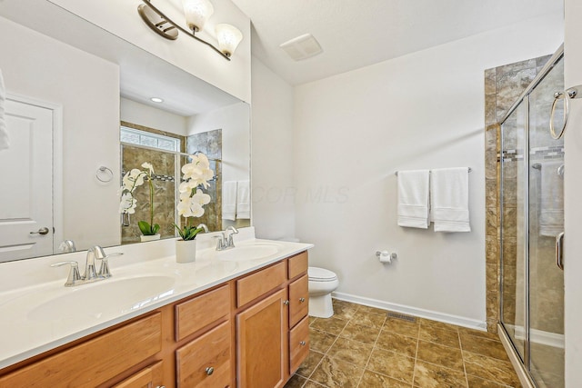 bathroom featuring a shower with door, vanity, and toilet