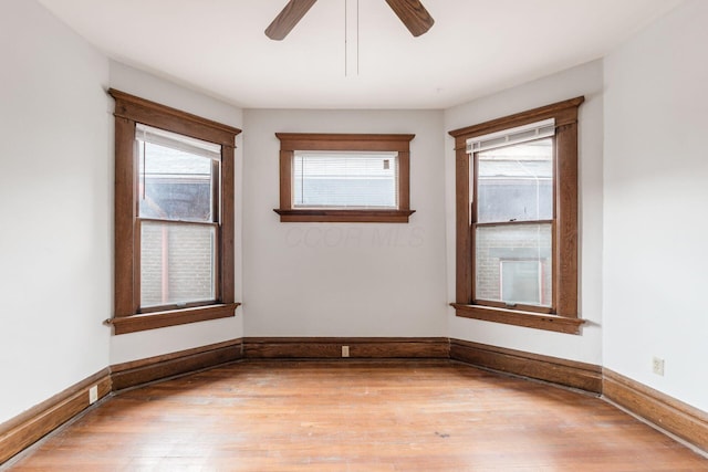 unfurnished room with hardwood / wood-style flooring, ceiling fan, and a wealth of natural light