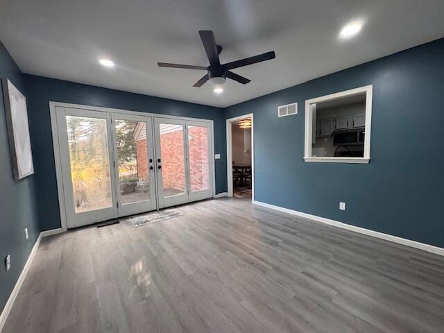 unfurnished room featuring french doors, hardwood / wood-style flooring, and ceiling fan