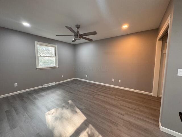 unfurnished room with ceiling fan and dark wood-type flooring