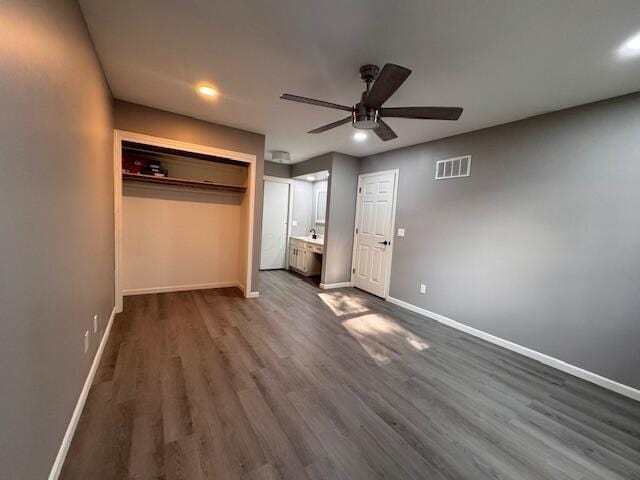 unfurnished bedroom with dark hardwood / wood-style floors, ceiling fan, ensuite bath, and a closet