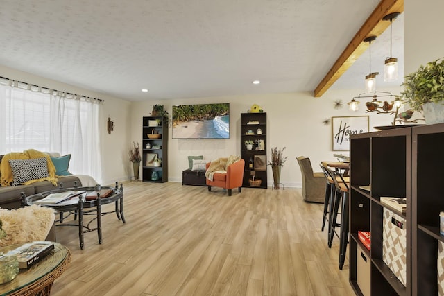 living room with beamed ceiling and light hardwood / wood-style flooring