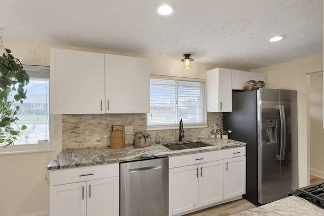 kitchen featuring appliances with stainless steel finishes, tasteful backsplash, and white cabinetry