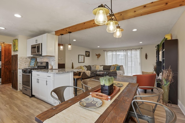 dining room with beam ceiling and light hardwood / wood-style flooring