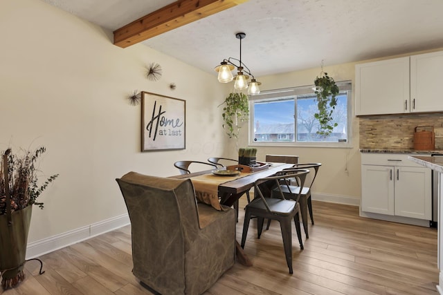 dining room featuring beamed ceiling and light hardwood / wood-style flooring