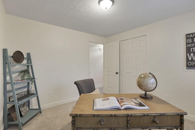 carpeted home office with a textured ceiling