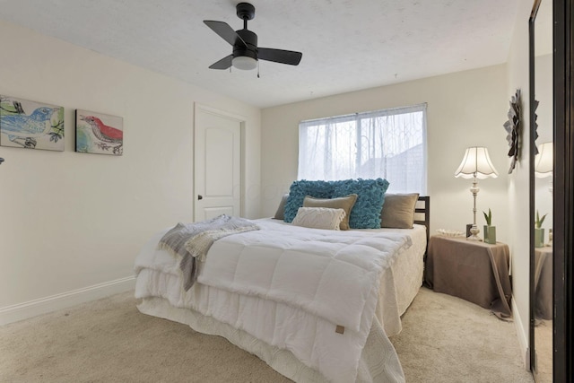 bedroom featuring light colored carpet and ceiling fan