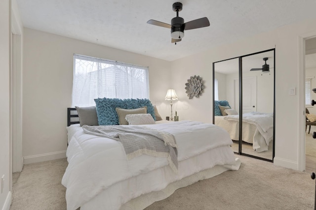 bedroom featuring ceiling fan, a closet, and light colored carpet