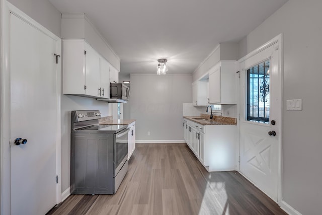 kitchen with white cabinets, hardwood / wood-style floors, sink, and electric stove