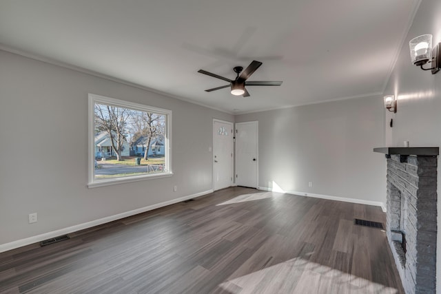 unfurnished living room featuring ceiling fan, a fireplace, dark wood-type flooring, and ornamental molding