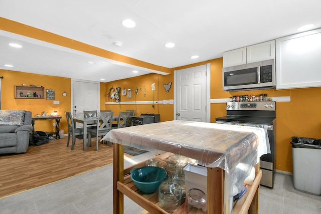 kitchen with white cabinets, stainless steel appliances, and light hardwood / wood-style floors