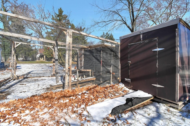 yard layered in snow with a storage shed