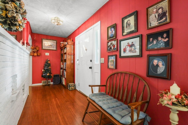 hallway with a textured ceiling and hardwood / wood-style flooring