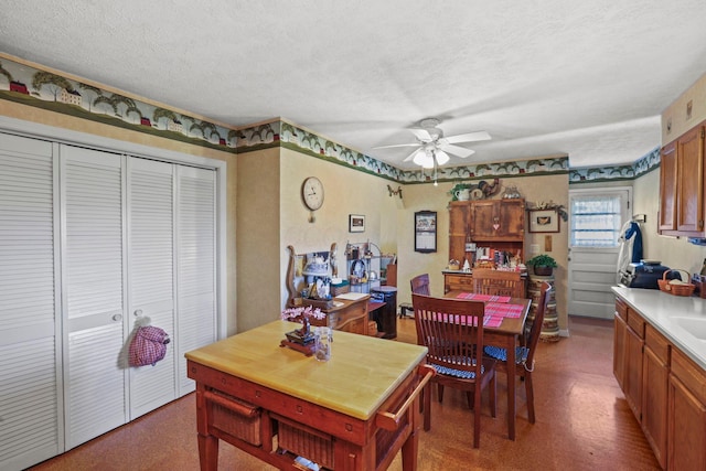 dining space featuring a textured ceiling and ceiling fan