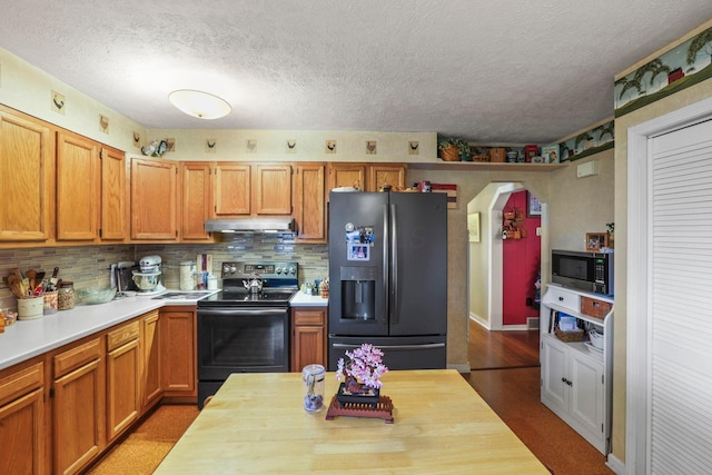 kitchen featuring a textured ceiling, appliances with stainless steel finishes, and tasteful backsplash