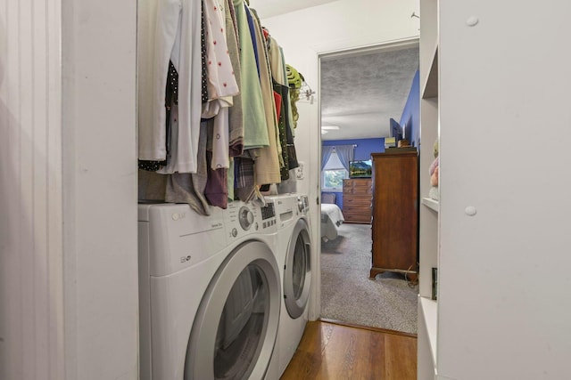 laundry room featuring dark hardwood / wood-style flooring, separate washer and dryer, and a textured ceiling