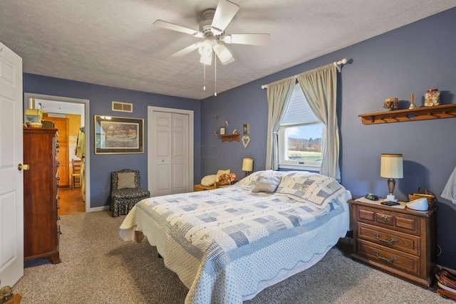 bedroom featuring ceiling fan, light colored carpet, a textured ceiling, and a closet