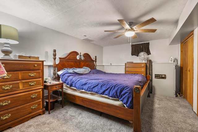 bedroom with light carpet, ceiling fan, and a textured ceiling