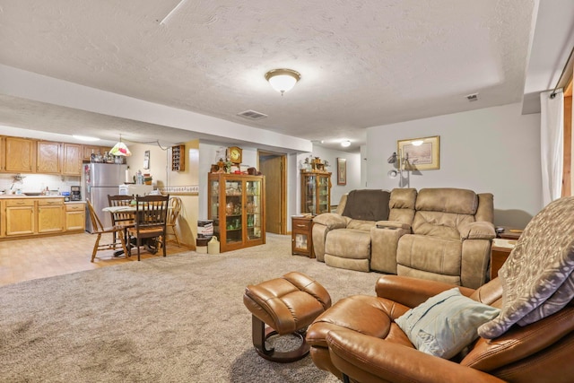 carpeted living room featuring a textured ceiling