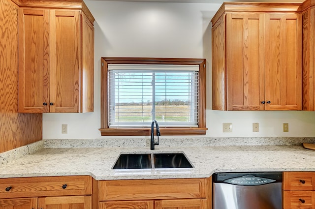 kitchen featuring dishwasher, light stone countertops, and sink