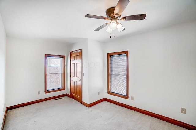 spare room featuring ceiling fan and light carpet